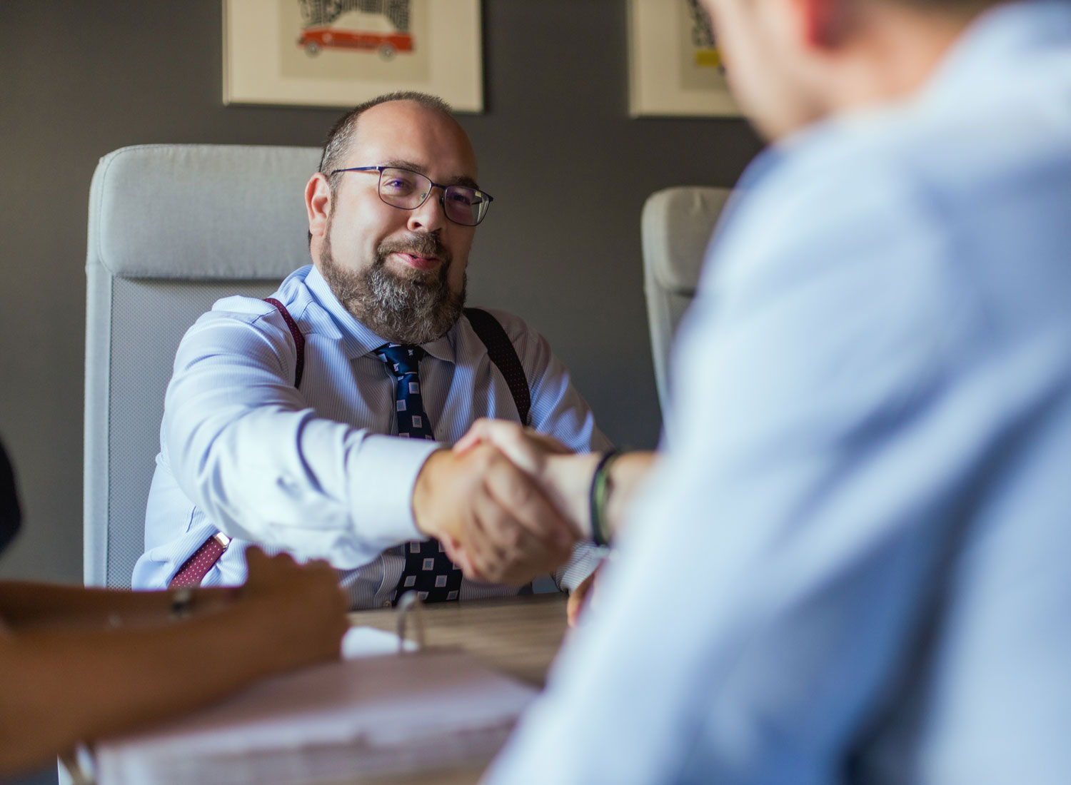 an accident lawyer in the Cayman Islands shakes hands with a client in a conference room