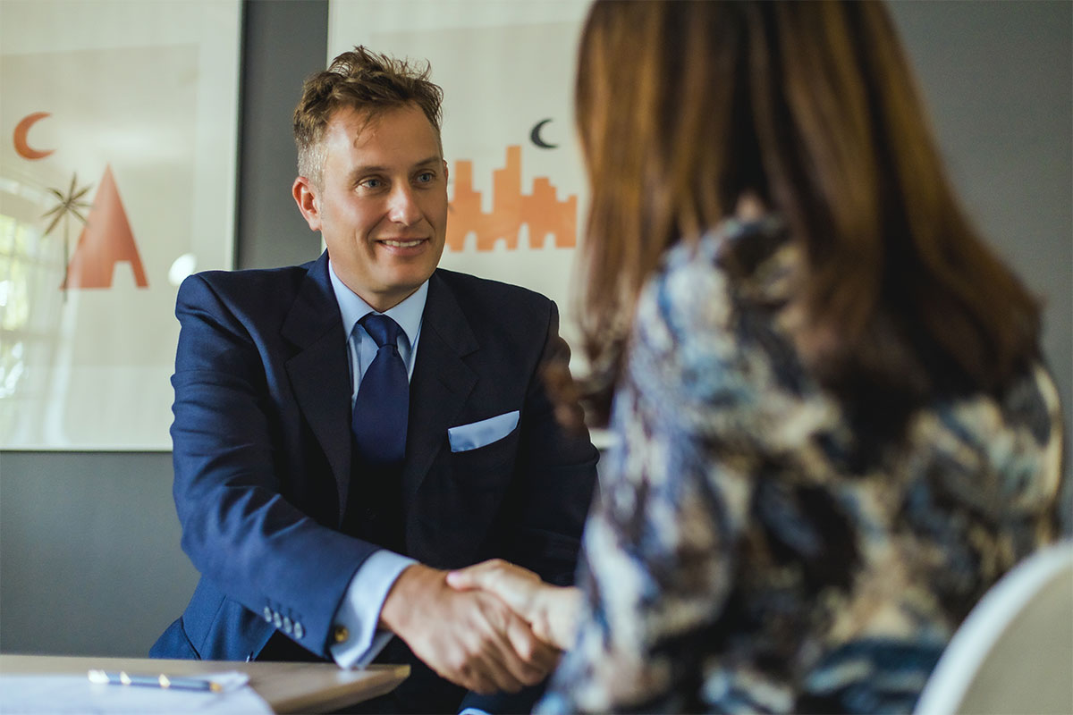 an attorney discusses Cayman Islands trust law with an associate while shaking his hand